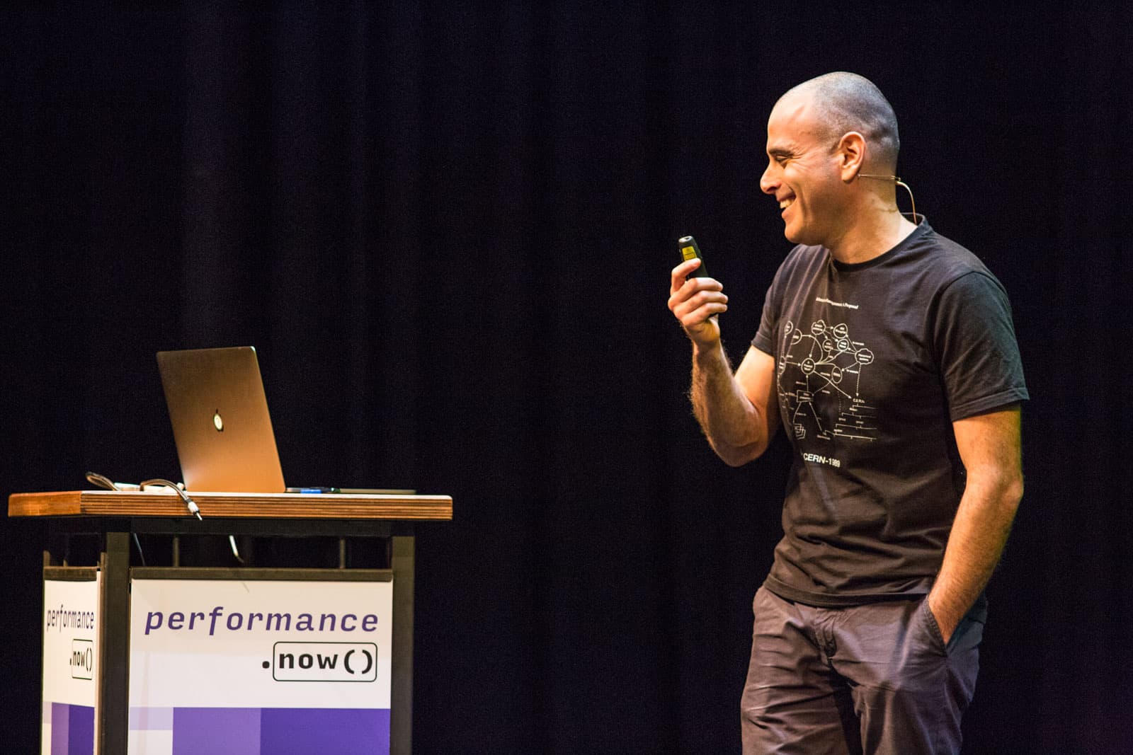 Me on stage at performance.now(). Holding a clicker and smiling, while seemingly transitioning slides.